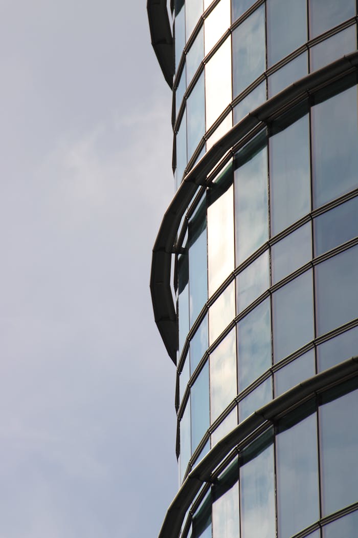 Close-up of a modern skyscraper's glass facade reflecting the sky.